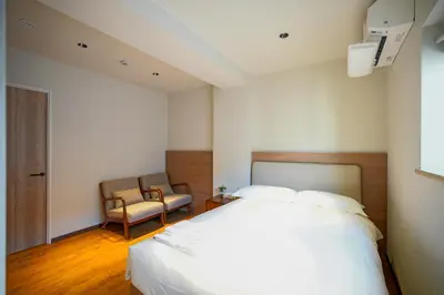 a bedroom with a white bed and a chair at Nakano World Hotel in Tokyo