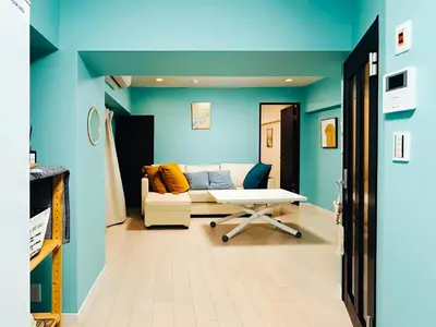 a living room with blue walls and a couch at shinjuku kasa 1302 in Tokyo
