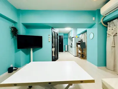 a blue room with a bed and a flat screen tv at shinjuku kasa 1302 in Tokyo