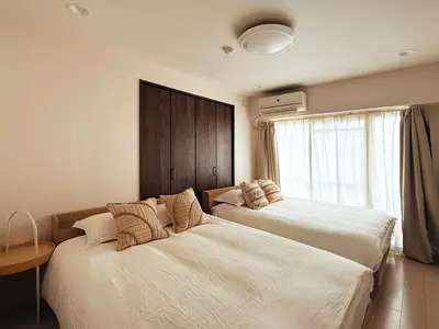a bedroom with two beds and a window at shinjuku kasa 1302 in Tokyo