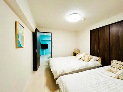 a bedroom with two beds and a mirror at shinjuku kasa 1302 in Tokyo