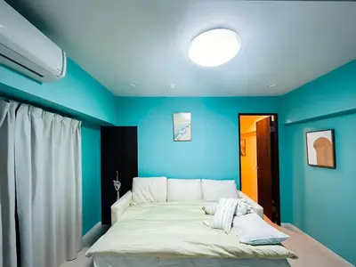 a bedroom with blue walls and a large bed at shinjuku kasa 1302 in Tokyo