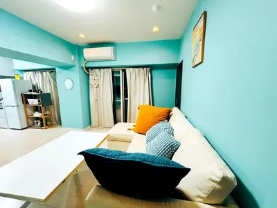 a living room with blue walls and a couch at shinjuku kasa 1302 in Tokyo
