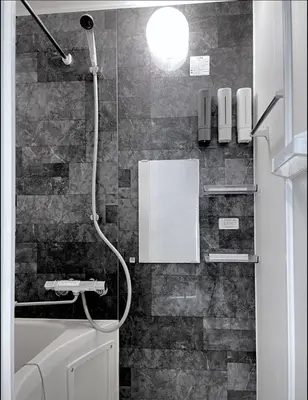 a bathroom with a shower with a phone on the wall at GLANNIR Higashi kitazawa 402 in Tokyo