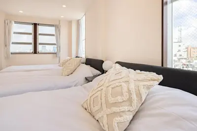 a bedroom with two white beds and a window at Tokyo Modern Sakura House Gakugei 7min Shibuya by TRAIN Sakura River 10 min in Tokyo