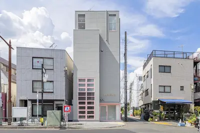 a tall building on the corner of a street at Tokyo Modern Sakura House Gakugei 7min Shibuya by TRAIN Sakura River 10 min in Tokyo