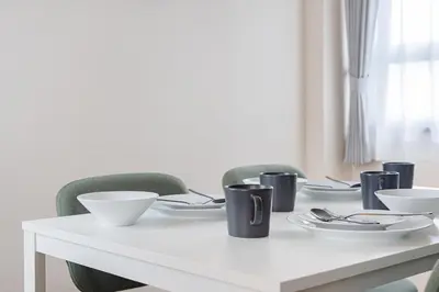 a white table with chairs and plates on it at Tokyo Modern Sakura House Gakugei 7min Shibuya by TRAIN Sakura River 10 min in Tokyo