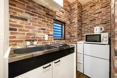 a kitchen with a sink and a brick wall at Tokyo Modern Sakura House Gakugei 7min Shibuya by TRAIN Sakura River 10 min in Tokyo
