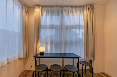 a table with four chairs in front of a window at Tokyo Modern Sakura House Gakugei 7min Shibuya by TRAIN Sakura River 10 min in Tokyo
