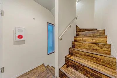 a staircase in a house with wooden floors and a window at Tokyo Modern Sakura House Gakugei 7min Shibuya by TRAIN Sakura River 10 min in Tokyo