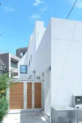 a house with white walls and wooden doors at monthly Grand Maison Natsumezaka in Tokyo