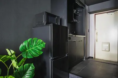 a kitchen with a refrigerator with a tv on top at SLL Urban Suites Shibuya in Tokyo