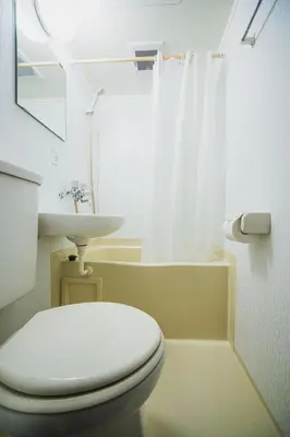 a white bathroom with a toilet and a sink at SLL Urban Suites Shibuya in Tokyo