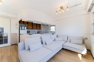 a white living room with a white couch and a kitchen at Vacation Stay Sanesu in Tokyo