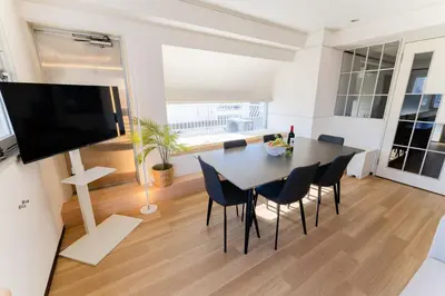 a dining room with a table and chairs and a flat screen tv at Vacation Stay Sanesu in Tokyo