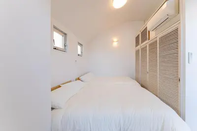 a white bedroom with a white bed with a window at Vacation Stay Sanesu in Tokyo