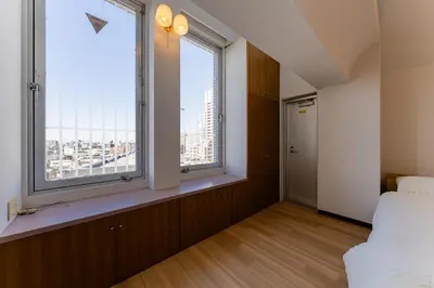 a bedroom with a bed and two large windows at Vacation Stay Sanesu in Tokyo