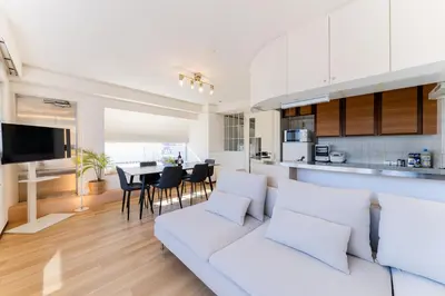a living room with a white couch and a kitchen at Vacation Stay Sanesu in Tokyo
