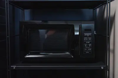 a black microwave oven with a persons face inside at SLL Urban Suites Akasaka in Tokyo