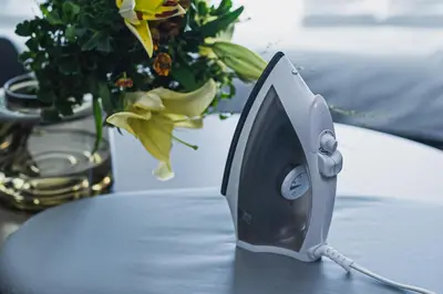 a iron sitting on a table next to a vase of flowers at SLL Urban Suites Akasaka in Tokyo
