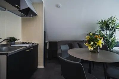 a kitchen with a table and a sink and a table with flowers at SLL Urban Suites Akasaka in Tokyo