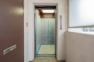 a glass door leading into a room with a window at Diamond Mansion Apartment Hotel in Tokyo
