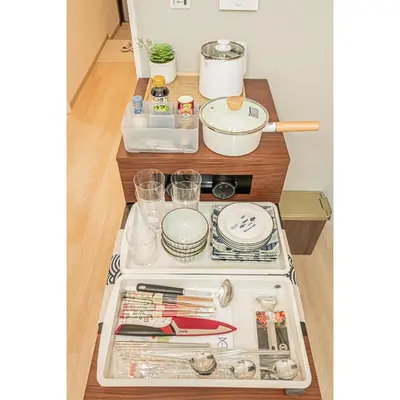 a kitchen counter with a stove and some dishes at Diamond Mansion Apartment Hotel in Tokyo