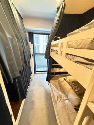 a dorm room with bunk beds and a window at Wabi Sabi Hostel Shinjuku West in Tokyo