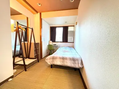a small bedroom with a bed and a window at Wabi Sabi Hostel Shinjuku West in Tokyo