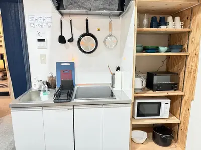 a kitchen with a counter with a sink and a microwave at Wabi Sabi Hostel Shinjuku West in Tokyo