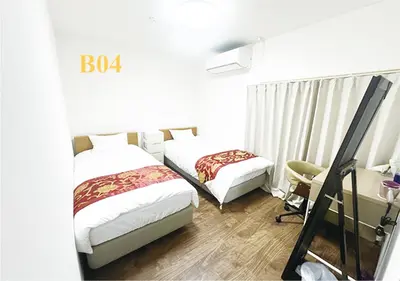 a hotel room with two beds and a desk and a desk at Tabata Flower Village - Vacation STAY 45936v in Tokyo