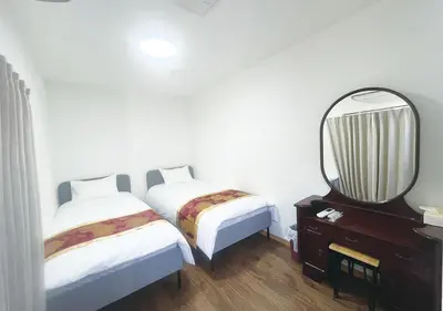 a bedroom with two beds and a mirror and a dresser at Tabata Flower Village - Vacation STAY 45954v in Tokyo