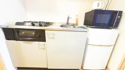 a small kitchen with a microwave and a refrigerator at Ars Building 303 - Vacation STAY 46091v in Tokyo