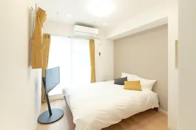 a bedroom with a white bed and a television at Gaia Bosco - Vacation STAY 76602v in Tokyo