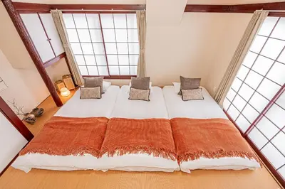 a large bed in a room with two windows at Mi-APT Kitashinjuku in Tokyo