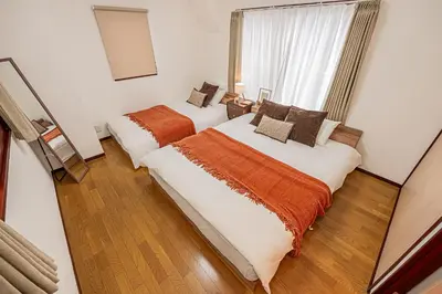 two beds in a room with a window at Mi-APT Kitashinjuku in Tokyo