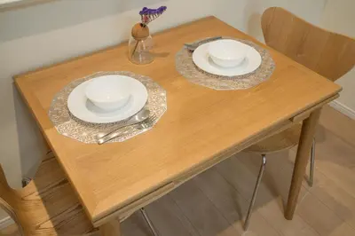 a wooden table with two plates and a vase with flowers at HoshiyoriTokyo in Tokyo