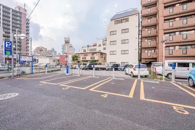 a parking lot with parked cars in a city at MDM Koiwa 2nd 303 2 bedrooms 5min from keisei koiwa station 60 min from Narita airport in Tokyo