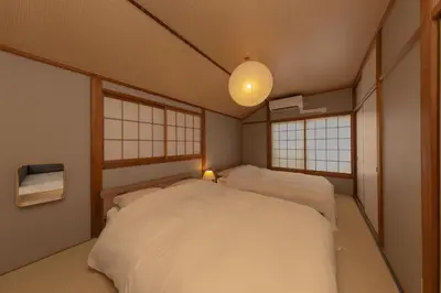two beds in a room with two windows at Karabiner House Ikebukuro in Tokyo