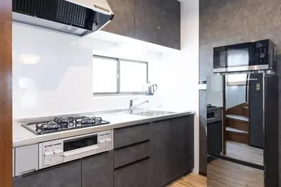 a kitchen with a sink and a refrigerator at Karabiner House Ikebukuro in Tokyo