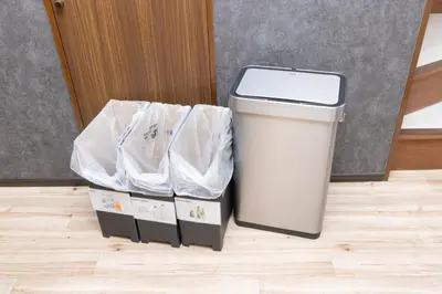 a trash can sitting on a floor next to a door at Karabiner House Ikebukuro in Tokyo