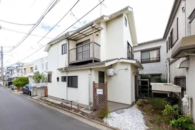 a white house with a balcony on a street at Karabiner House Ikebukuro in Tokyo