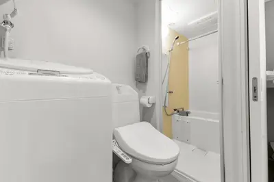 a white bathroom with a toilet and a shower at 3\u540d\u5bbf\u6cca \u897f\u65b0\u5bbf\u30a2\u30d1\u30fc\u30c8\u30e1\u30f3\u30c8 in Tokyo