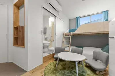 a small room with a bunk bed and a table and chairs at 3\u540d\u5bbf\u6cca \u897f\u65b0\u5bbf\u30a2\u30d1\u30fc\u30c8\u30e1\u30f3\u30c8 in Tokyo
