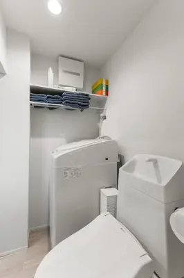 a white bathroom with a toilet and a sink at 3\u540d\u5bbf\u6cca \u897f\u65b0\u5bbf\u30a2\u30d1\u30fc\u30c8\u30e1\u30f3\u30c8 in Tokyo