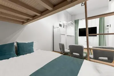 a bedroom with a bed and two chairs at 3\u540d\u5bbf\u6cca \u897f\u65b0\u5bbf\u30a2\u30d1\u30fc\u30c8\u30e1\u30f3\u30c8 in Tokyo