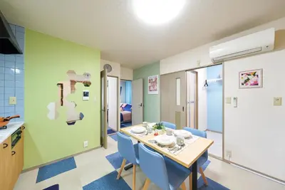 a dining room with a table and blue chairs at Shamrock Aoto 302 Cozy Tokyo Stay Near Station Airport Disney Access in Tokyo