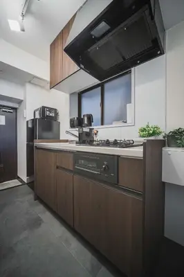 a kitchen with wooden cabinets and a stove top oven at ERIKO HOTEL Azabujuban in Tokyo