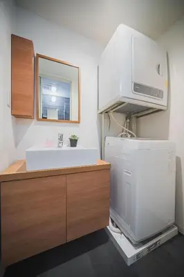 a kitchen with a sink and a microwave above a refrigerator at ERIKO HOTEL Azabujuban in Tokyo