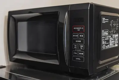 a black microwave oven sitting on top of a counter at ERIKO HOTEL Azabujuban in Tokyo